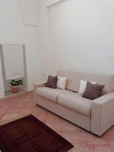 a white couch in a living room with a rug at Appartamento Le Volte in Soleto
