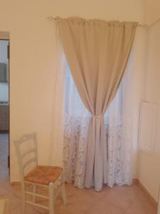 a curtain and a chair in a room at Appartamento Le Volte in Soleto