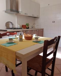 a kitchen with a table with a yellow table cloth at Appartamento Le Volte in Soleto