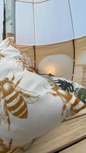 a bed with a painting of a bee on it at La Colmena Glamping in El Rosario