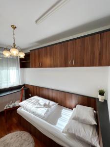 1 dormitorio con 1 cama con cabecero de madera en Vilmos apartman, en Pécs