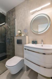 a bathroom with a toilet and a sink and a mirror at Club Panorama Lake View Apartment in Alsóörs