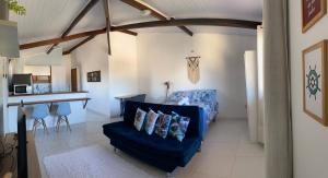 ein Wohnzimmer mit einem blauen Sofa und einem Tisch in der Unterkunft Loft Studio - MAR AZUL in Lauro de Freitas