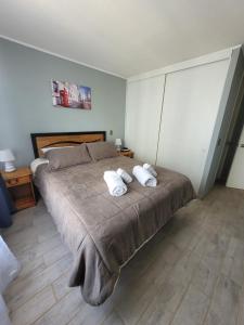 a bedroom with a large bed with two pillows on it at Disfruta Depto. Antofagasta in Antofagasta