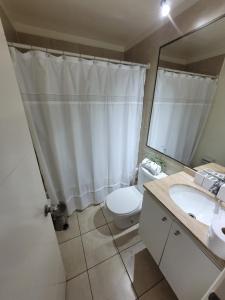 a bathroom with a toilet and a sink and a mirror at Disfruta Depto. Antofagasta in Antofagasta