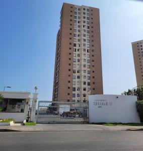 un edificio alto con una valla delante en Disfruta Depto. Antofagasta, en Antofagasta