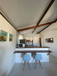 eine Küche mit einem Tisch und 2 blauen Stühlen in der Unterkunft Loft Studio - MAR AZUL in Lauro de Freitas