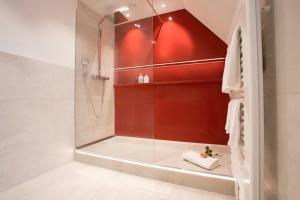 a shower with a glass door in a bathroom at Romantik Berghotel Astenkrone in Winterberg