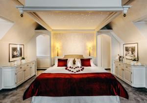 a bedroom with a large bed with two dressers at Romantik Berghotel Astenkrone in Winterberg
