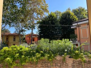 a brick wall with flowers in a garden at Borgogna 14 in Reggio Emilia