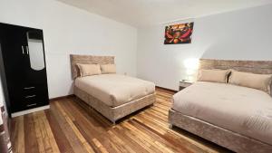 mały pokój z 2 łóżkami i lustrem w obiekcie Valicha Casa Hotel w Cuzco