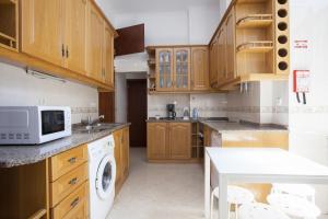 a kitchen with wooden cabinets and a washer and dryer at FLH Baixa Comfortable Apartment in Lisbon