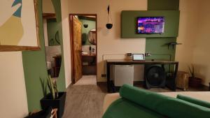 a living room with a couch and a tv on the wall at Puerto Bamboo in Máncora