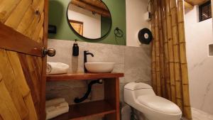 a bathroom with a toilet and a sink and a mirror at Puerto Bamboo in Máncora