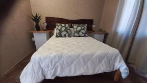 a bedroom with a bed with a white comforter and pillows at 4BFarming Rest camp and Camping in Naris