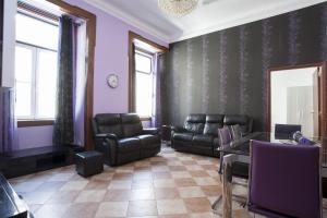 a waiting room with black leather furniture and purple walls at FLH Baixa Comfortable Apartment in Lisbon