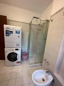 een badkamer met een wasmachine en een wastafel bij Lo scrigno in Chiozzola