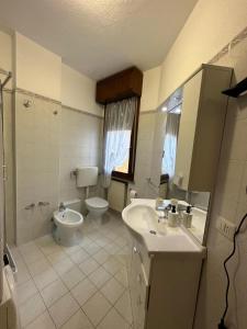 een badkamer met een toilet, een wastafel, een bad en een toilet bij Lo scrigno in Chiozzola