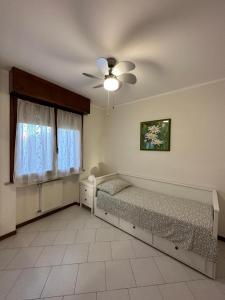 een slaapkamer met 2 bedden en een plafondventilator bij Lo scrigno in Chiozzola