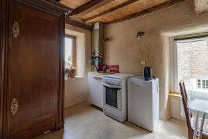 a small kitchen with a stove and a refrigerator at Les Jeux du Vent -Saint Jacut de la mer in Saint-Jacut-de-la-Mer