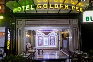 ein Restaurant-Zugang zu einem goldenen Kuli des Hotels mit Neonschild in der Unterkunft Golden Pen Hotel in Istanbul