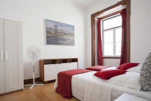 a bedroom with a bed with red pillows and a window at FLH Baixa Comfortable Apartment in Lisbon