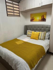 a bedroom with a bed with a yellow blanket on it at Entire apartment 