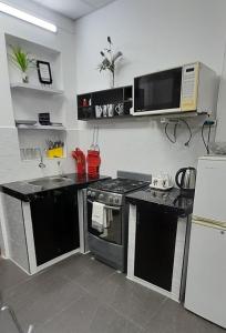 a kitchen with a stove and a microwave at Casablanca 4 in Tacna