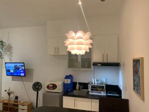 a kitchen with a chandelier hanging from the ceiling at Scandi Minimalist Mckinley Hill BGC in Manila