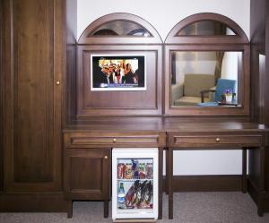 um armário de madeira com um espelho e um frigorífico em Golden Pen Hotel em Istambul