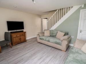 a living room with a couch and a flat screen tv at Fisherman's Retreat in Mirfield