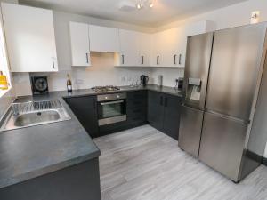 a kitchen with white cabinets and stainless steel appliances at Fisherman's Retreat in Mirfield