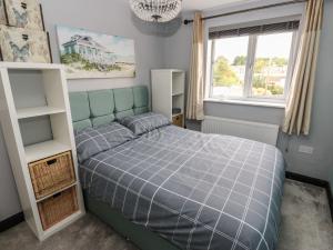 a bedroom with a blue bed and a window at Fisherman's Retreat in Mirfield