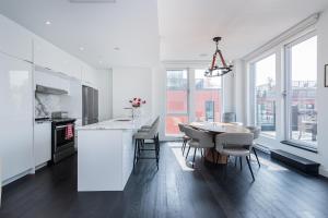 a kitchen and dining room with a table and chairs at Le Se7t Penthouses in Montréal
