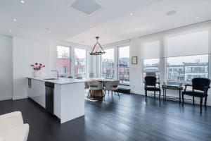 a white kitchen and dining room with a table and chairs at Le Se7t Penthouses in Montreal