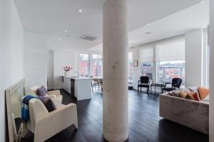 a living room with white furniture and a column at Le Se7t Penthouses in Montreal