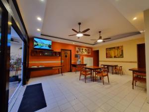 a dining room with tables and a flat screen tv at Hotel Plaza Cozumel in Cozumel