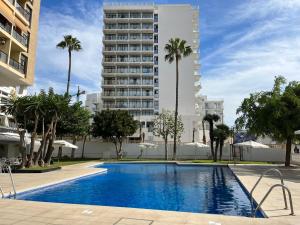 basen przed wysokim budynkiem w obiekcie Beach Apartment - Benalmadena Costa w mieście Benalmádena