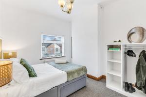 a small bedroom with a bed and a window at Silver Stag Properties, 3 BR Gem with 2 Baths in Hugglescote