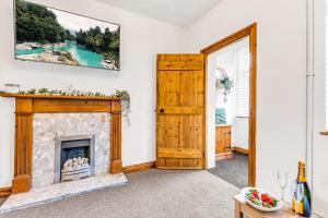 a living room with a fireplace and a painting on the wall at Silver Stag Properties, 3 BR Gem with 2 Baths in Hugglescote