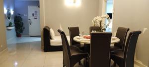 a dining room with a table and black chairs at Bintang Lux B&B Suites Times Square KL in Kuala Lumpur