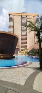 a large building with a pool in front of it at Bintang Lux B&B Suites Times Square KL in Kuala Lumpur