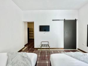 ein Schlafzimmer mit zwei Betten und einem Fernseher an der Wand in der Unterkunft DGM Lofts MTY MN 960 B centro cerca de todo in Monterrey