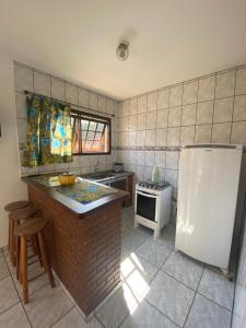 イリャベラにあるChalés e suítes Lourençoのキッチン(白い冷蔵庫、コンロ付)