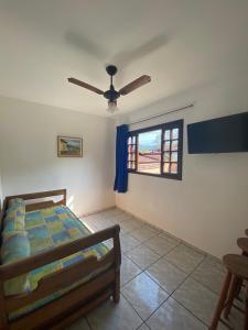 1 dormitorio con cama y ventana en Chalés e suítes Lourenço, en Ilhabela