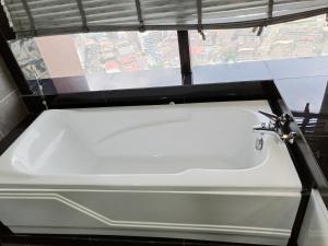 a white bath tub in a bathroom with a window at Bintang Lux B&B Suites Times Square KL in Kuala Lumpur