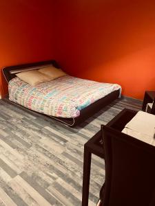 a small bedroom with a bed and a table at Chambre indépendante in Saint-Chély-dʼApcher