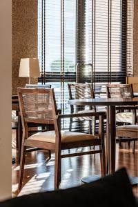a room with tables and chairs and a large window at Hotel Dom Goncalo & Spa in Fátima