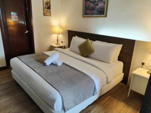 a bedroom with a large bed with white sheets and pillows at Bintang Lux B&B Suites Times Square KL in Kuala Lumpur