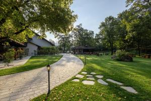a brick walkway in a park with a building at Penzion Pibernik in Bled